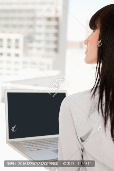 她辦公室里的女人手里拿著一臺筆記本電腦