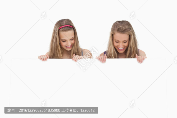 兩個年輕女子抱著一張空白板