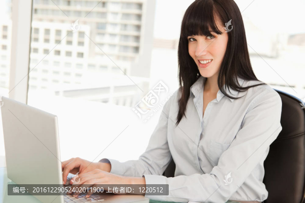 一個(gè)女人看著她的筆記本電腦上的相機(jī)類型