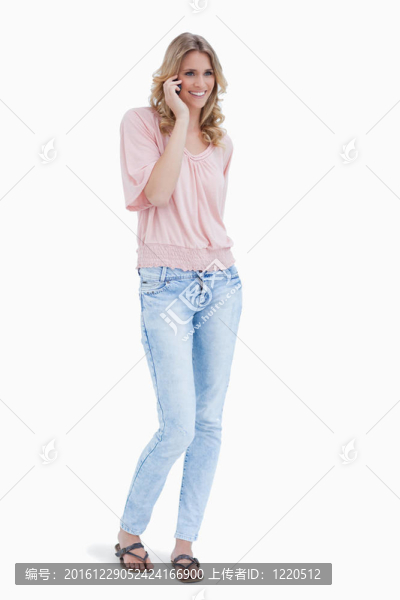 一個面帶微笑的女人站在她的手機旁