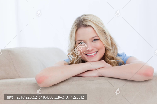 一個微笑的女人在她的手上休息下巴