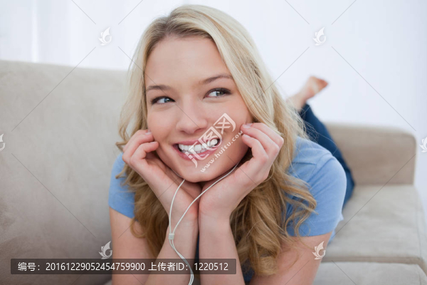一個(gè)微笑的女人用她的耳機(jī)聽音樂