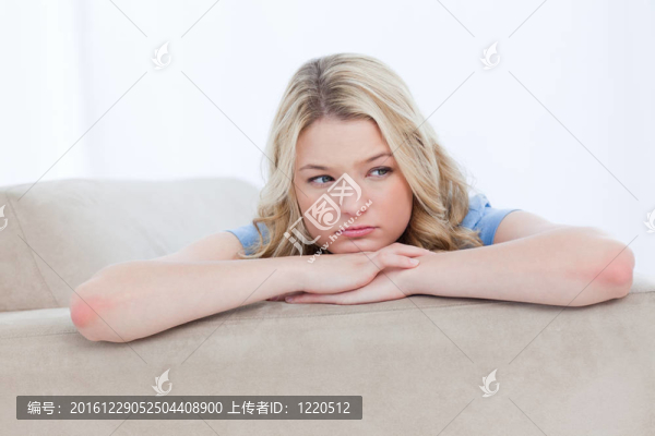 一個年輕女人把頭靠在手上思考