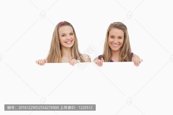 兩個年輕女子抱著一個空白的標(biāo)志