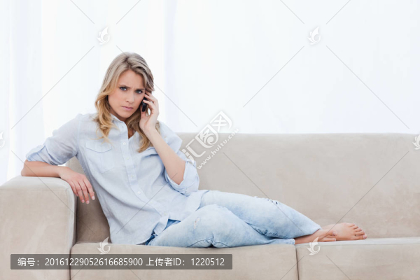 一個看著相機的女人正在用手機說話