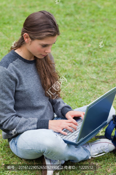 嚴重的年輕女孩在筆記本電腦打字，而看著SCR