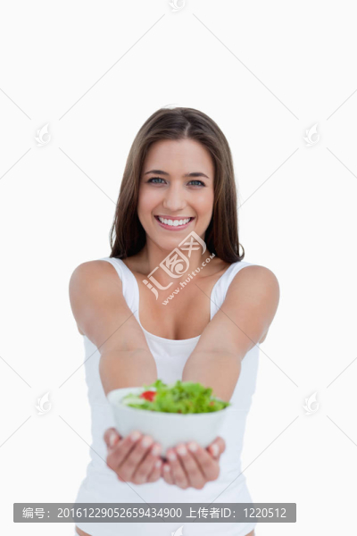 微笑的年輕女子拿著沙拉