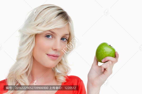 迷人的女人抱著一個(gè)綠色的蘋(píng)果看著