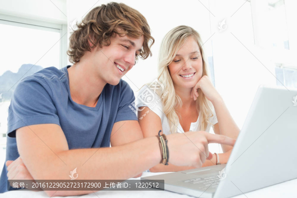 微笑的夫婦一起看筆記本電腦