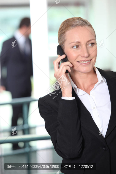 在辦公室環(huán)境中使用手機的精明商業(yè)女性
