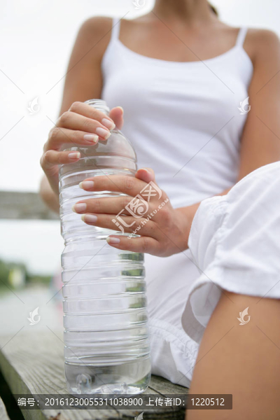拿著一瓶水的女人