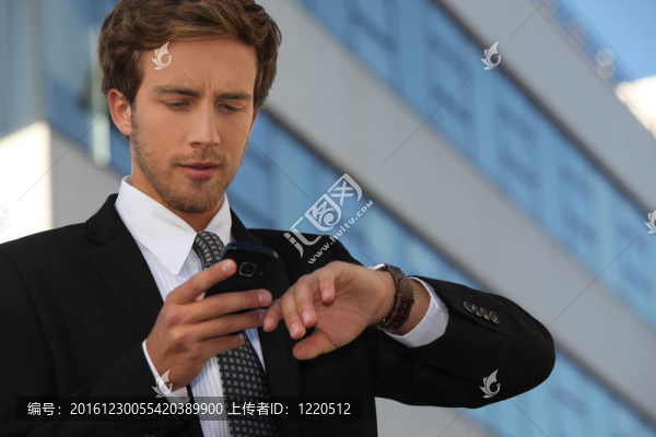 城市商人檢查他的手表和他的電話
