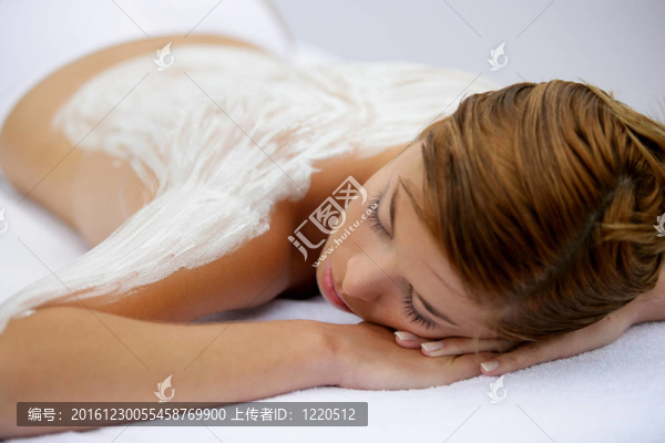 年輕女子在背部涂上奶油