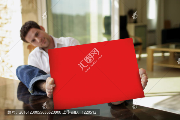 男人坐在院子里用紅色海報