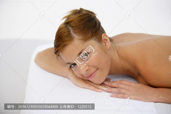 微笑的女人躺在按摩臺上