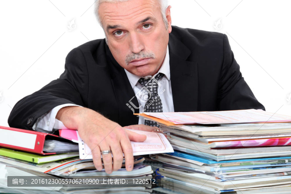 灰色毛茸茸的男人看著面前的紙工作