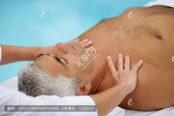 成熟的男人在按摩的旁邊有一個游泳池