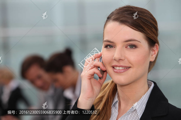 一個(gè)年輕的女人打電話，在辦公室里看著我們。