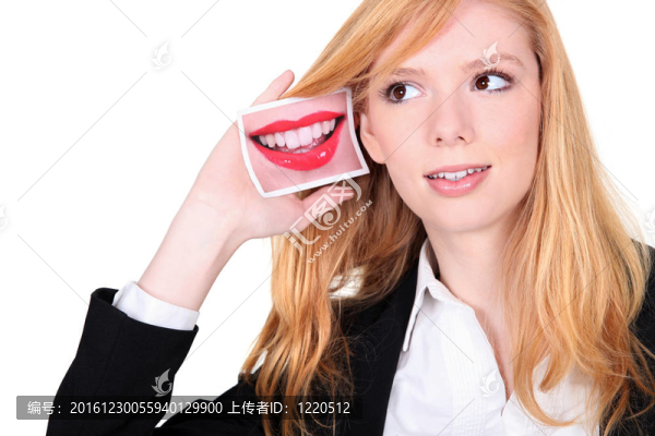 年輕女子拿著一張嘴對著她的耳朵