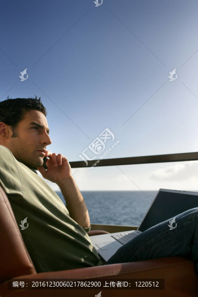 沉思的人與海洋的筆記本電腦