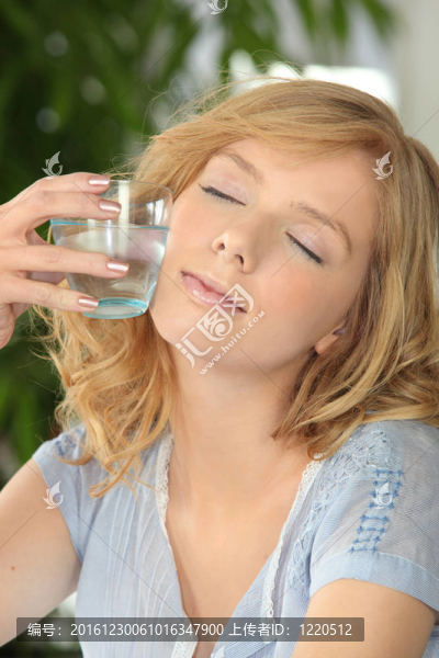 女人閉著眼睛拿著一杯水