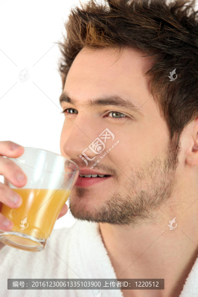 男人喝一杯橙汁