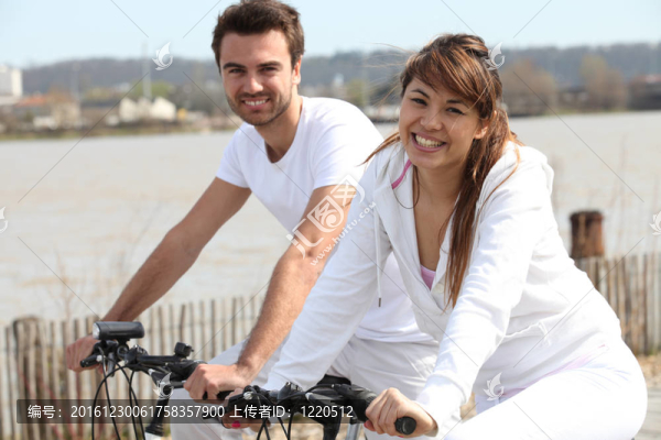 年輕夫婦在海邊做自行車