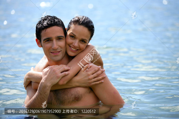 年輕夫婦擁抱在水中