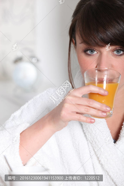 穿著果汁的女人拿著一杯橙汁