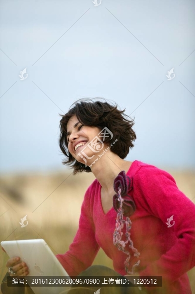 快樂的女人坐在一場與筆記本電腦