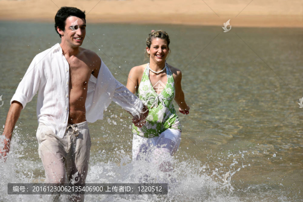 嬉戲的年輕夫婦穿過水