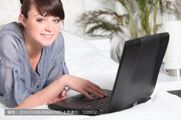 可愛的女人在床上使用筆記本電腦