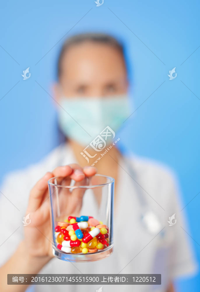 藥片和藥片在醫(yī)生的手上堆積在藍(lán)色的背景上