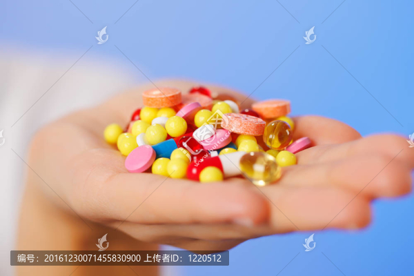 藥片和藥片在醫(yī)生的手上堆積在藍色的背景上