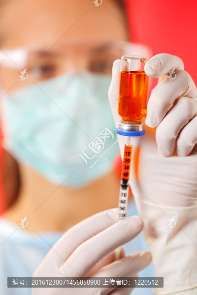 年輕的女醫(yī)生與紅安瓿和注射器準(zhǔn)備注射