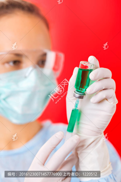 年輕的女醫(yī)生與紅安瓿和注射器準(zhǔn)備注射