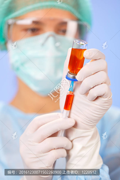 年輕的女醫(yī)生在藍色的安瓿和注射器準備注射