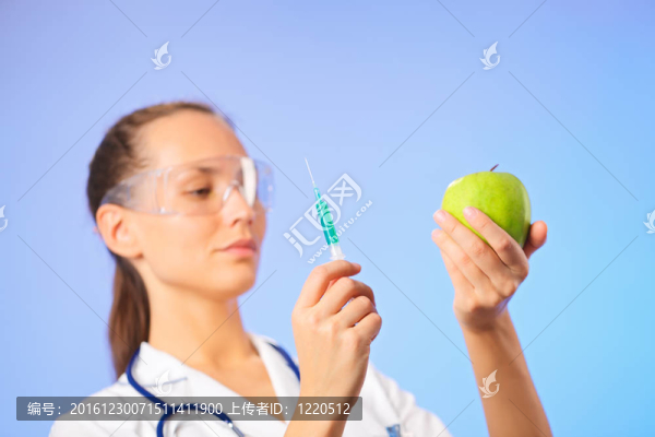 年輕女子用綠色注射器注射綠色蘋果