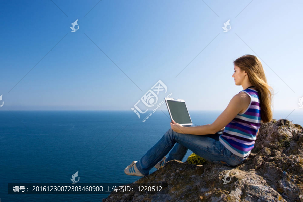 婦女與筆記本電腦和海洋