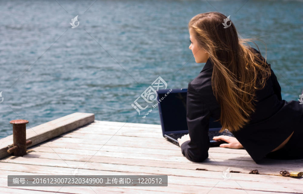 婦女與筆記本電腦和海洋