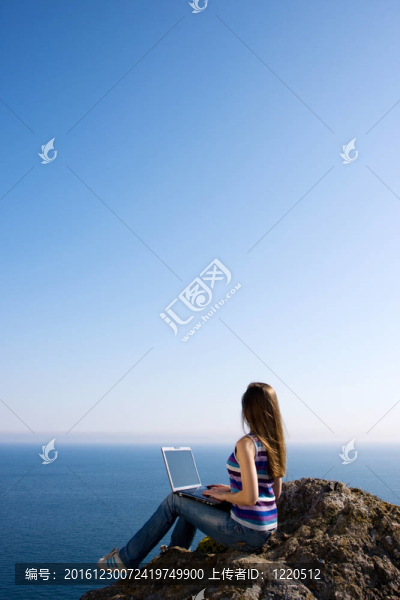 婦女與筆記本電腦和海洋