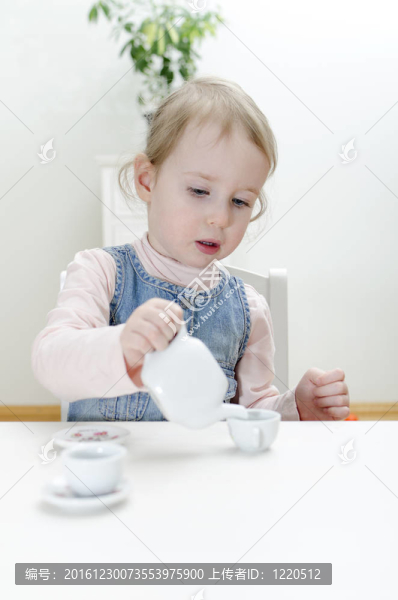 可愛的小女孩在家喝茶。