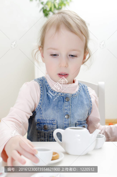 可愛的小女孩喝茶與面包圈