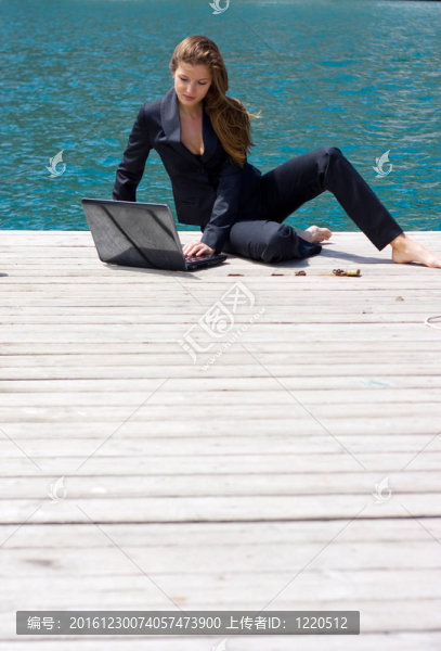 婦女與筆記本電腦和海洋