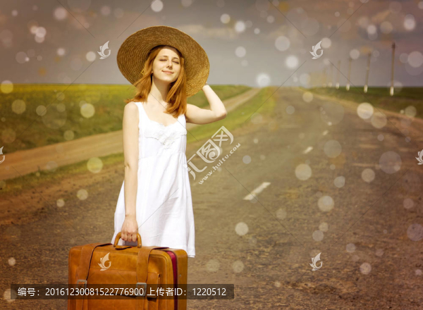鄉(xiāng)村路上帶著手提箱的寂寞女孩。
