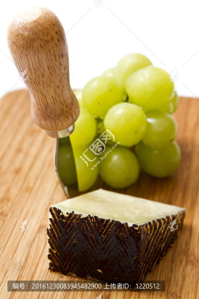 曼徹格奶酪和葡萄在案板上