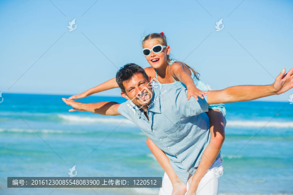 父親和女兒在海灘上玩得很開心