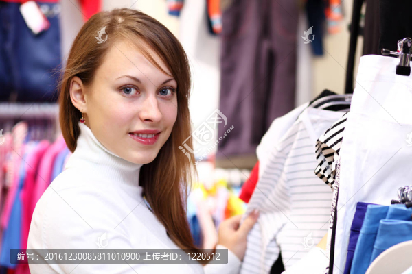 年輕女人在商店里買(mǎi)衣服