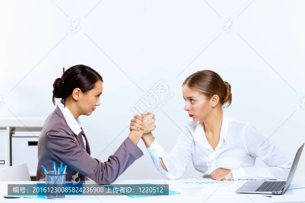 年輕婦女手臂在辦公室摔跤