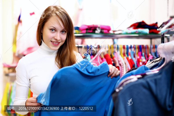 年輕女人在商店里買(mǎi)衣服